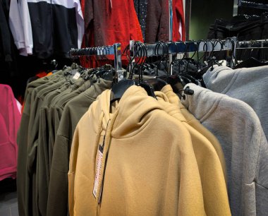 Giyim mağazasının içinde renkli kazaklı askılar..