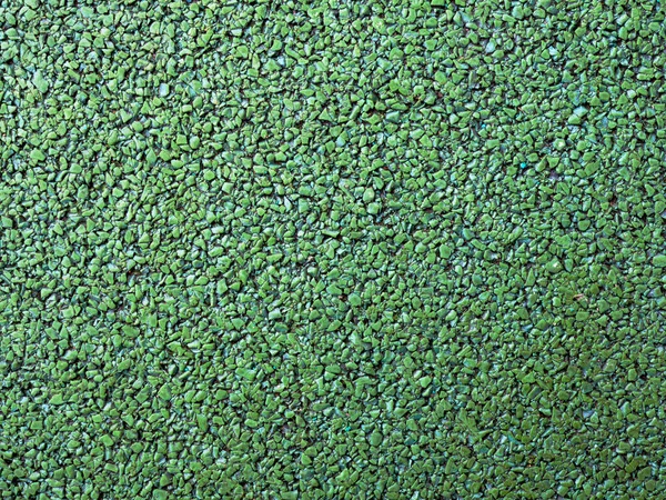 Flexible green tile for playground. Tiles made from a mixture of rubber crumb.