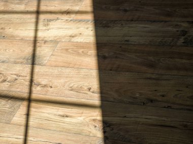 Pencerenin gölgesi ahşap kalasların üzerine düşüyor..