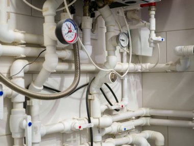 Su borularına yerleştirilmiş plastik top valfleri ve basınç göstergelerinin montajı.