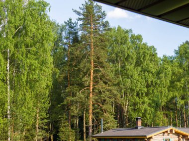 Özel bir evin terasının altından tuğladan bacası olan bir evin çatısına bak..