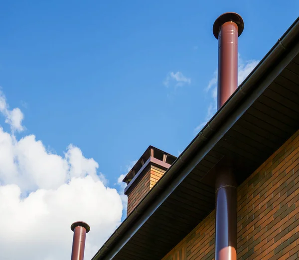 View of the brick wall and the roof with three chimneys of a private house. — 图库照片