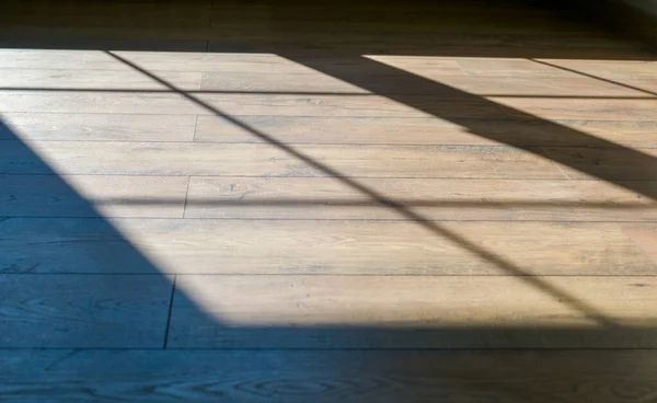 Stín z okna padající na podlahu z dřevěných prken. Stock Obrázky