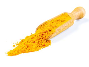 Ahşap bir kepçenin içinde yatan zemin zerdeçal köküne yakın plan. Beyaz bir arkaplanda izole edilmiş.