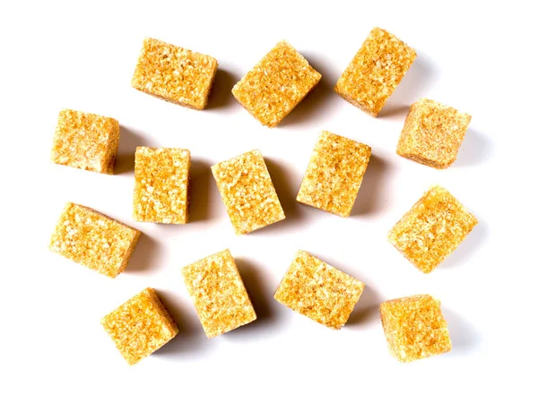 Close-up de pedaços de açúcar de cana marrom. Isolado sobre um fundo branco. — Fotografia de Stock