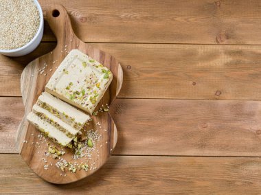 Kahverengi ahşap arka planda, meşe ağacının üzerinde fıstıklı susam halkası. Üst Manzara. Boşluğu kopyala.