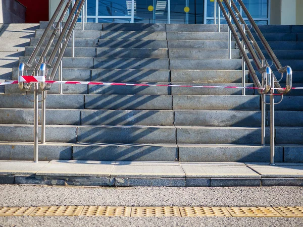 La escalera en frente de la entrada de la estación de tren está bloqueada por una cinta de señal. —  Fotos de Stock