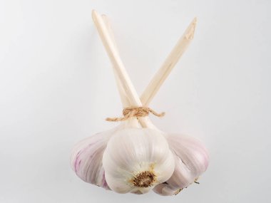 İple bağlanmış üç sarımsak kafanın yakın çekimi.