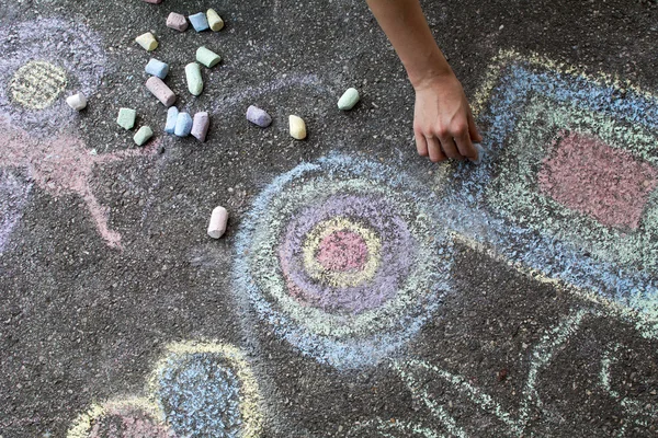 Frau malt mit farbiger Kreide auf Asphalt - Archivbild — Stockfoto