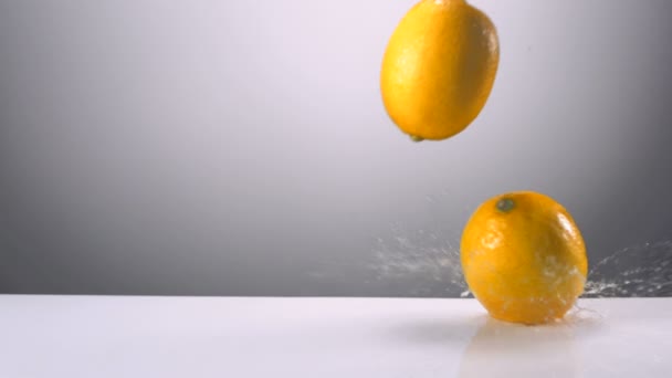 Limones enteros cayendo sobre el agua — Vídeo de stock