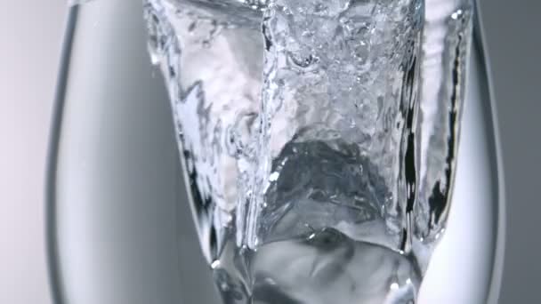 Ice dropped into water glass — Stock Video