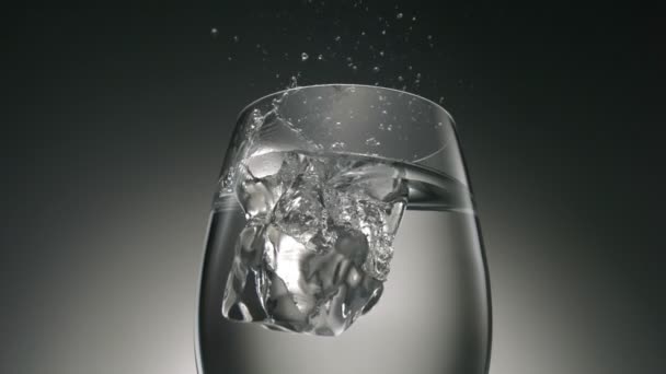 Ледяной куб падает в стекло — стоковое видео