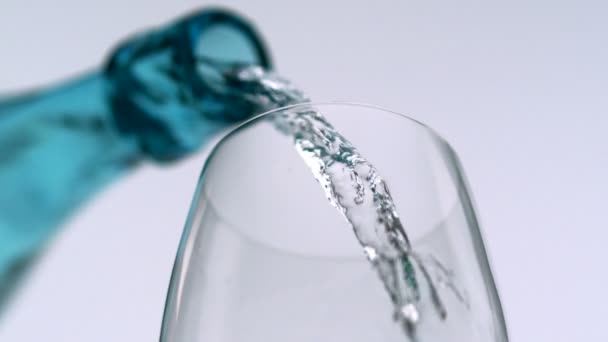 Наливание воды в стакан из бутылки — стоковое видео