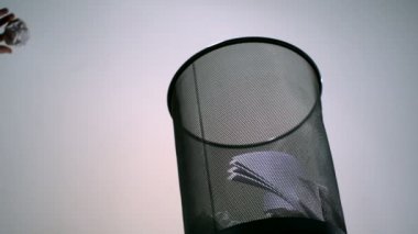 Ezilmiş kağıt çöp tenekesine savurma