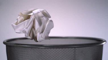 Ezilmiş kağıt çöp tenekesine savurma