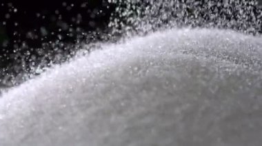 Şeker ile yüksek hızda çekim siyah arka plan üzerine yığını