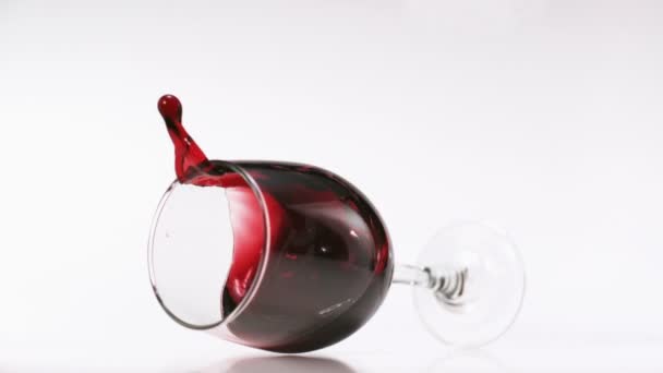 Red wine splashing out of glass — Stock Video