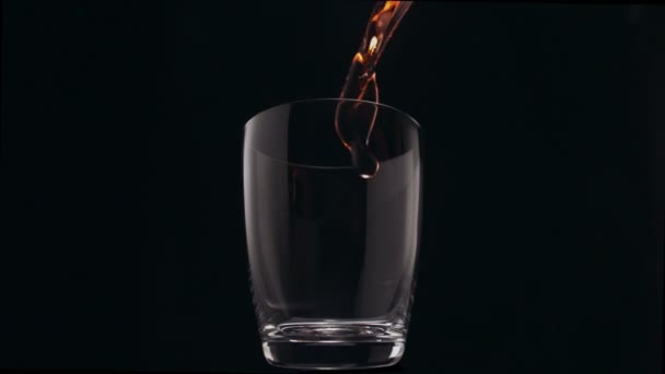 Eau rouge coulant dans le verre 