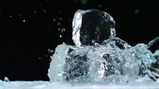 Salpicaduras de agua contra cubos de hielo — Vídeo de stock