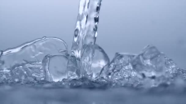 Verter agua sobre cubos de hielo — Vídeos de Stock