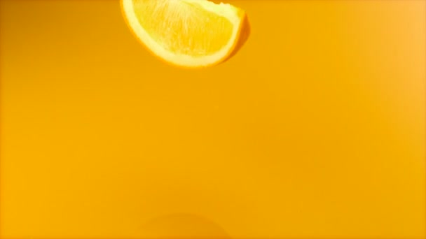 Laranja fatiada caindo em suco de laranja — Vídeo de Stock