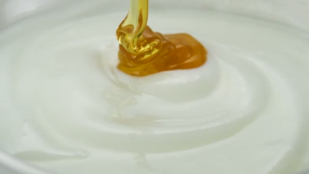 Pouring honey on yoghurt — Stock Video