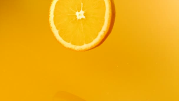 Naranja en rodajas cayendo en jugo de naranja — Vídeos de Stock