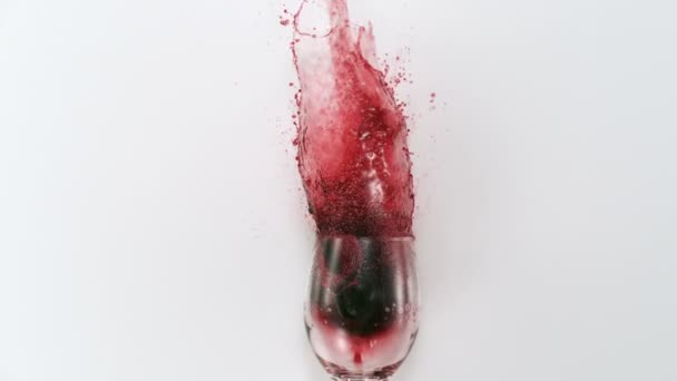 Красное вино, выплескивающееся из стекла — стоковое видео