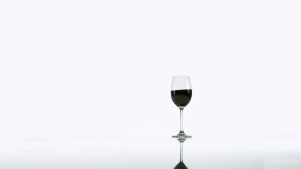 Wineglass with red wine tipping over — Stock Video