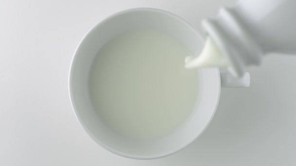 Verter la leche en la taza — Vídeo de stock
