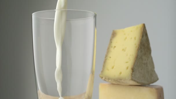 Pouring milk into glass with cheese — Stock Video