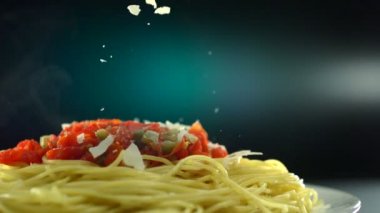 Spagetti üzerinde parmesan peyniri koyarak