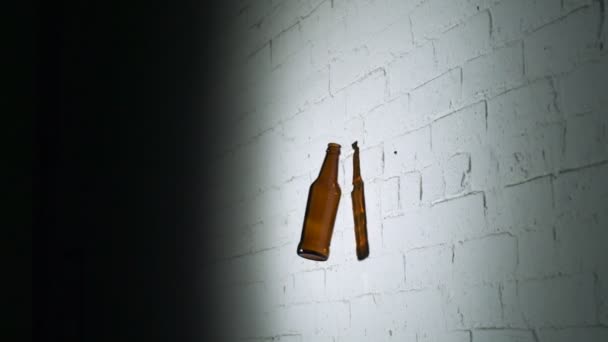 Rompiendo botella de vidrio vacío en la pared de ladrillo — Vídeos de Stock