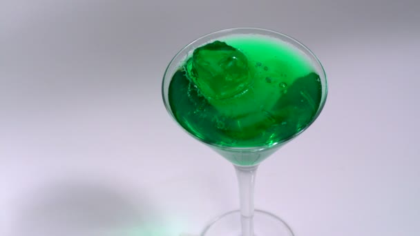 Green jelly falling in drink — Stock Video