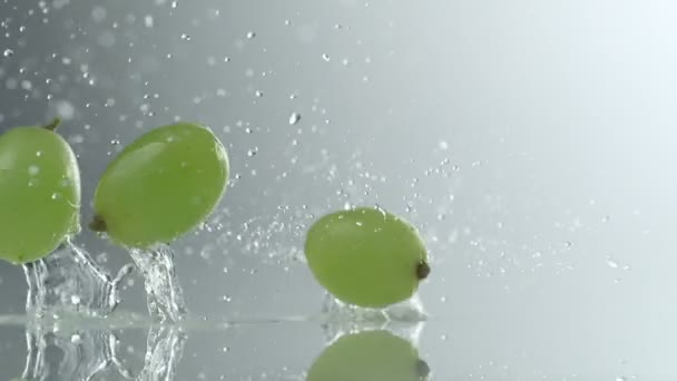 Druiven vallen op wateroppervlak — Stockvideo