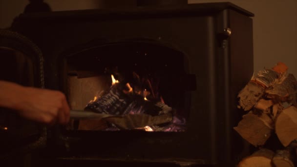 Mujer poniendo troncos en la chimenea — Vídeo de stock