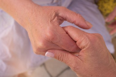 yaşlı bir adamın elini - kavramsal resmi tutan genç el.