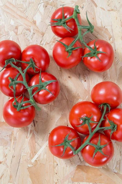 Close-up de tomates frescos e maduros sobre fundo de madeira — Fotografia de Stock