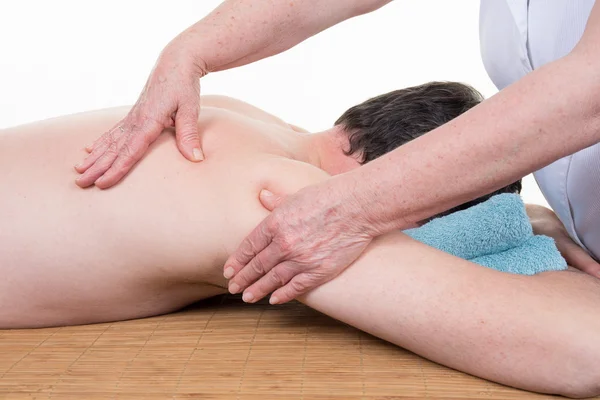 Masażysta wyrabiania mężczyzna powrotem skóry o masaż w salonie spa — Zdjęcie stockowe