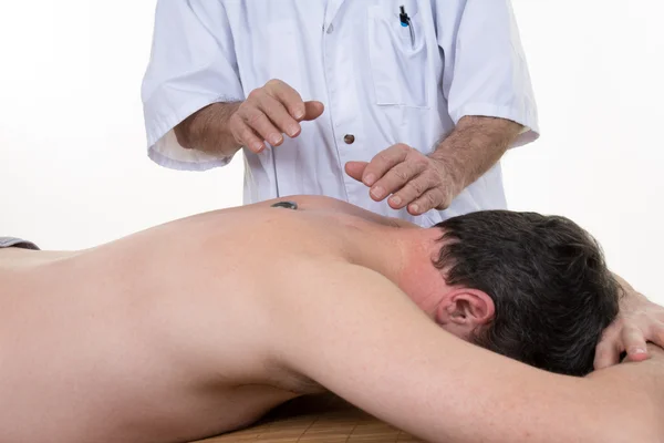 Uomo maturo sdraiato sulla schiena, ottiene massaggi, reiki, digitopressione sul viso, concentrarsi sul viso e le mani — Foto Stock