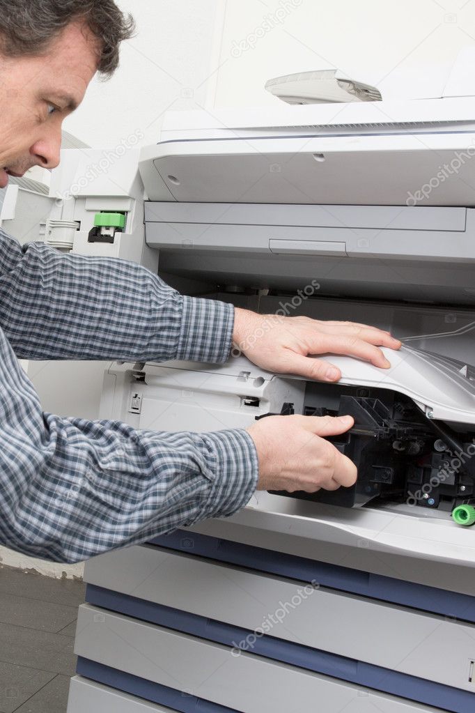 Shot male technician repairing digital photocopier machine