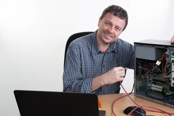 Hombre utilizando el ordenador portátil para comprobar los servidores en el centro de datos — Foto de Stock