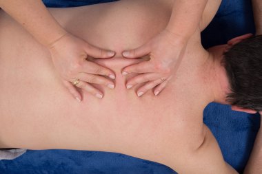 Spa 'da sırt masajı yapan bir masöz resmi.