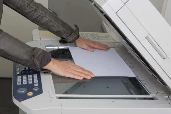 Woman's hand with working copier at work Royalty Free Stock Photos