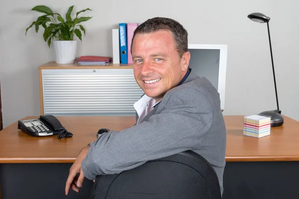 Portrait of a nice smiling man at desk at office