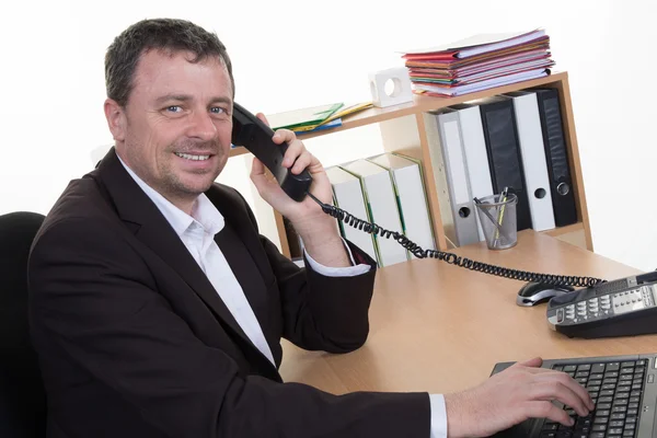 Veselý muž v úřadu nezvedá telefon v práci — Stock fotografie