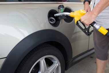 Adam bir otomobilin yakıt kap içinde başlık ekleme