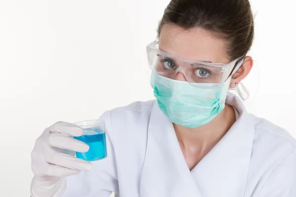 Brunette naispuolinen tiedemies suojaava suojalasit omistaa sininen neste putki — kuvapankkivalokuva