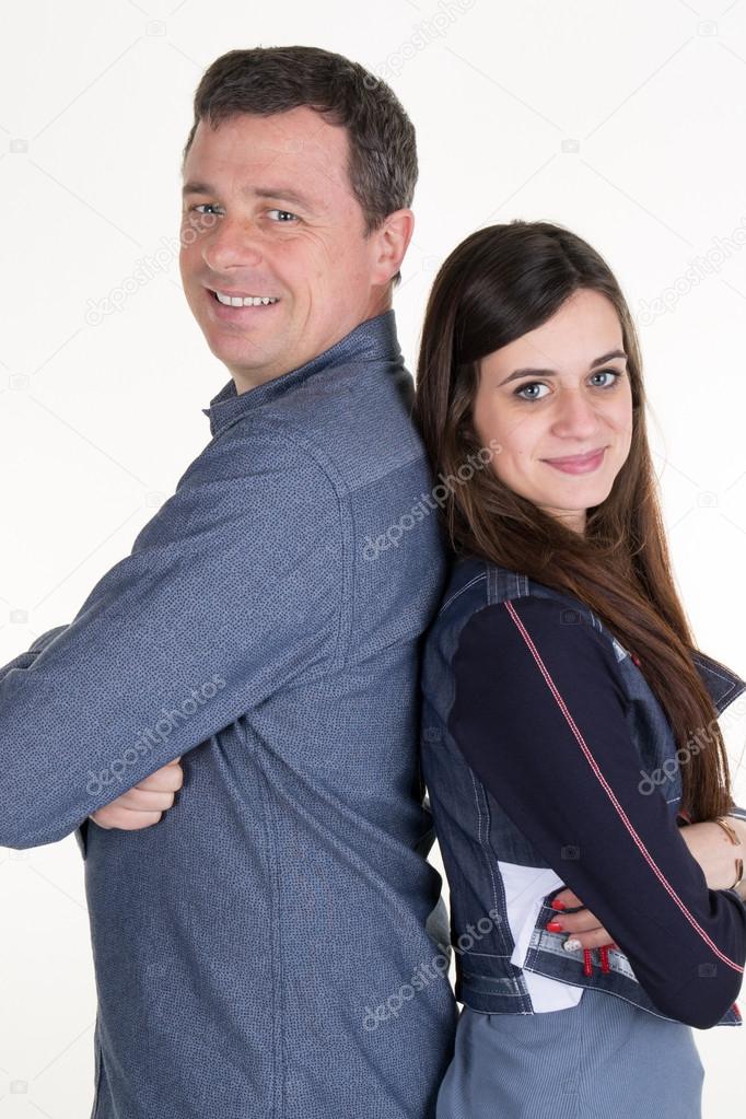 Cheerful couple standing back to back on white background