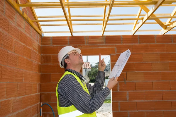 Man worker looking on the roof  in the new building — Stock Photo, Image